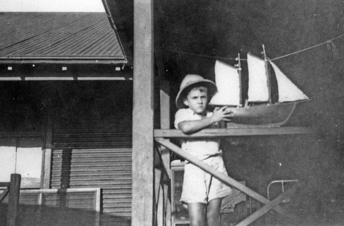 Boy holding a model boat.